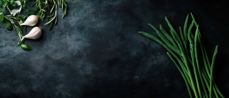 A collection of fresh herbs and green onions displayed on a dark stone surface creating a vibrant look perfect for culinary preparations.の素材