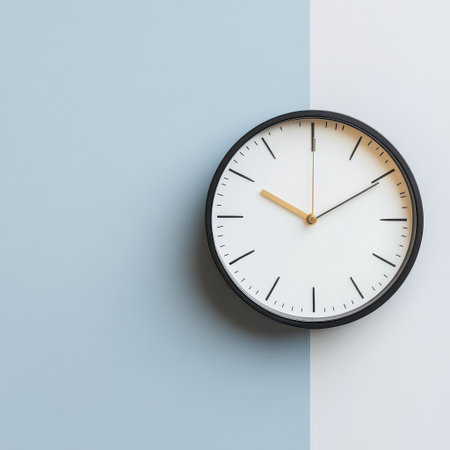 A wall clock with a minimalist design shows the time clearly against a split pastel background creating a stylish interior decor.の素材