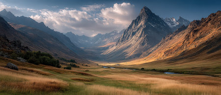 Golden hour casts warm light on rugged mountains and a lush valley with a flowing river and grassy fields in a serene landscape.の素材