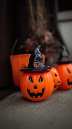 Colorful Halloween pumpkins with smiling faces and witch hats are placed decoratively creating a festive atmosphere for the holiday season.の素材