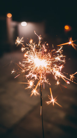 Exciting sparklers create a magical glow in the night sky as people gather to celebrate the New Year marking a joyful beginning.の素材