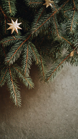 Green fir tree branches adorned with golden stars create a festive atmosphere perfect for welcoming the New Year with joy and elegance.の素材