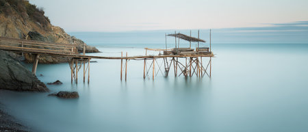 Soft waves lap against an old wooden pier during New Yearの素材