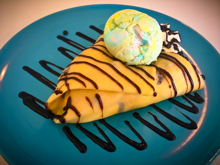 Cold crepe with chocolate, vanilla ice-cream and mousse on dish.の写真素材