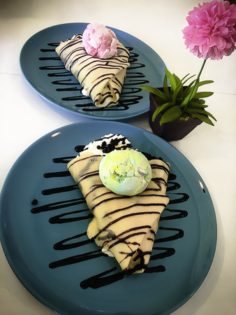 Cold crepe with chocolate, vanilla ice-cream and mousse on dish.の写真素材