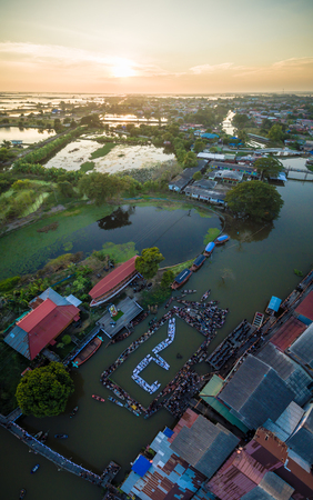 The people of Phak-Hai, Ayutthaya, Thailand. Gather for a dedication ceremony of mourning the death of His Majesty the King Bhumibol Adulyadej. People card stunts by boat on river. Mean "9" Thai number.の写真素材