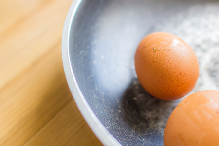 Fresh eggs in a pan on wooden floor.の写真素材