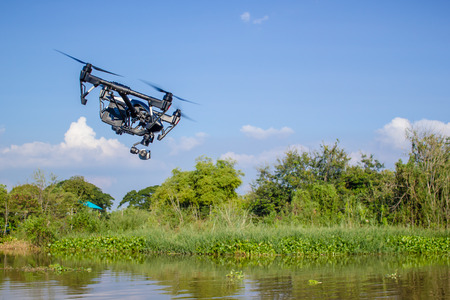 Professional camera drone fast flying on river.の写真素材
