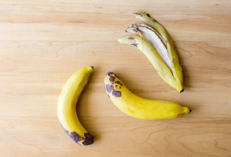 Two banana with banana peel on wooden floor.の写真素材