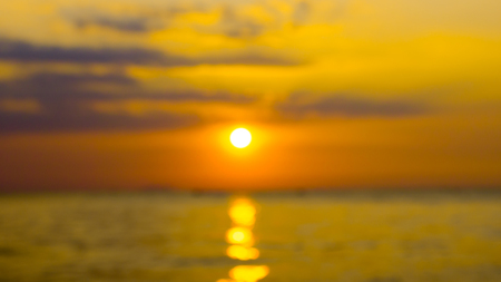 Blur sunset with golden sky and ocean at twilight.の写真素材