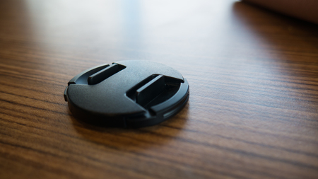 Lens cap for camera on wooden floor.の写真素材