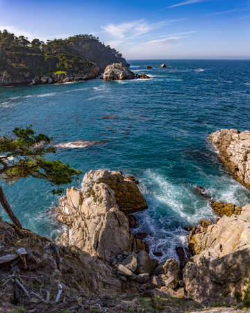 Crystal blue ocean views of the rough waters and textured rocksの写真素材