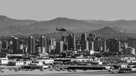 A military helicopter flies over the city of San Diego. The photo was taken from the Cabrillo national monument area.の写真素材