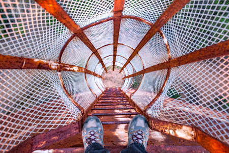 POV looking down a rusted old ladder on a water towerの写真素材