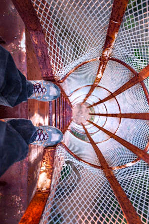 POV looking down a rusted old ladder on a water towerの写真素材