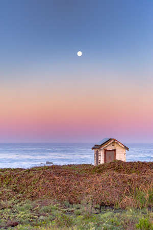 The moon glows in the first of the morning raysの写真素材