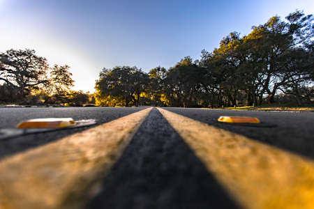 A shot from ground level of the dividing lines between lanes on Ortega Highway in Southern Californiaの写真素材