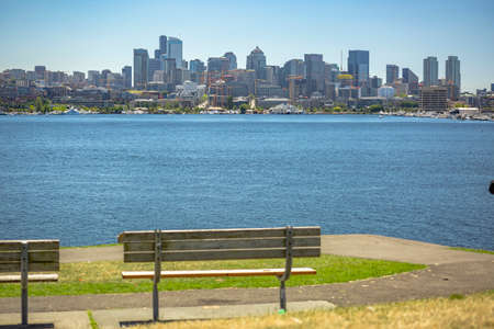 Sun over Seattle, park bench in the foreground. Park bench water and city skyline behindの写真素材