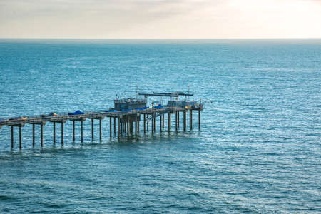 Scripps pier from a telephoto lens with a background of water and horizon. The coast of California near the Scripps pierの写真素材