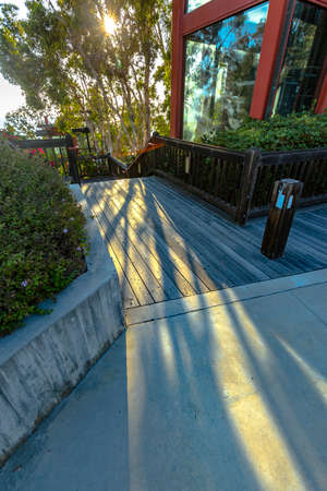 Light beams spilling onto the floor outside a modern building. Golden hour and contrast lighting with sunbeams in a modern building on the coast of Californiaの写真素材