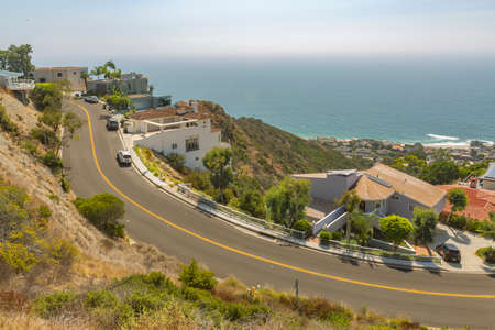 Coastal views of homes in Laguna Beach California. Coastal views of homes in Laguna Beach California. Wide curved uphill road in Laguna Beach California during a sunny day on the coastの写真素材