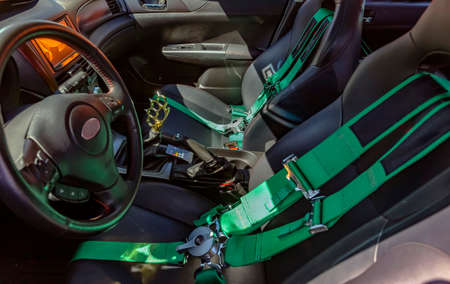 Automobile front seats with green seat belts and straps. Custom cars in Southern California summer...