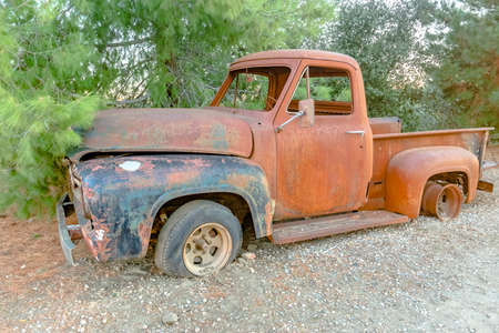 Forest Relic Old Car rusting away in the Forest on gravel. Broken down rusted old car with most...