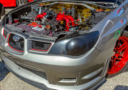 Under the hood of a car on exhibit with grey and red parts. Custom cars in Southern California...