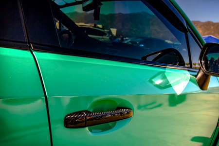 Green color horizontal shot of a car door handle. Various vehicle details in Southern California.の写真素材
