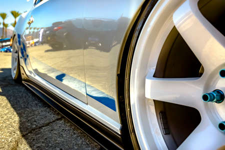 White rims with blue trimming of a close up on a car and wheels. Various tires at a southern California event. の写真素材