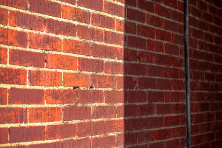 Brick wall with sun and shade for half