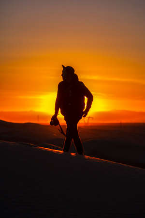 Man walks with camera in front of sunの写真素材