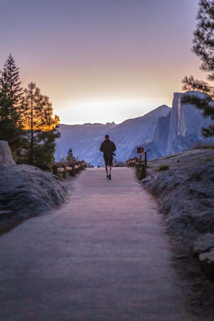 Man walks with camera toward Glacier Point