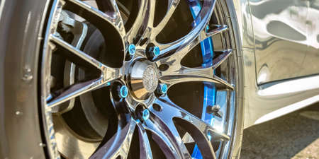 White car with silver tire rim and blue boltsの写真素材