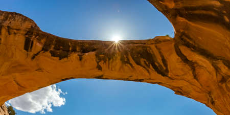 Sun peeking through Uranium Arch in Moab Utahの写真素材