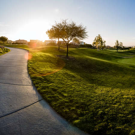 Sidewalk and building near a golf course at sunsetの写真素材