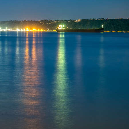 Boat lights reflected on ocean in Tacoma at sunsetの写真素材