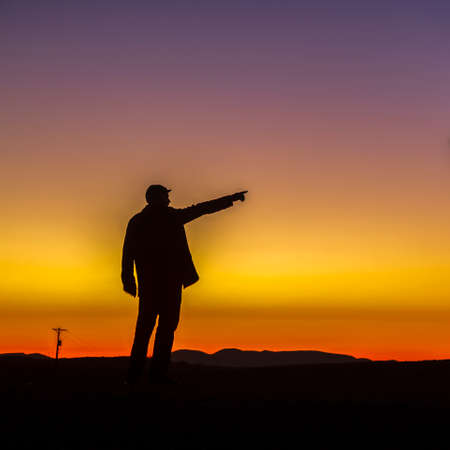 Golden horizon and silhoutte of a man at sunsetの写真素材