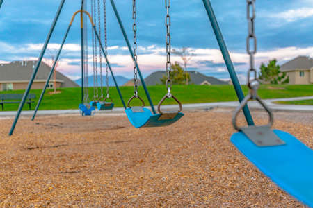 Swing with homes and mountain in the backgroundの写真素材
