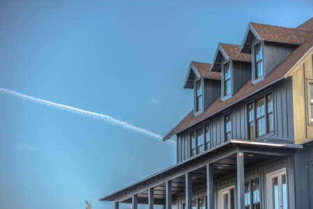 Sunlit home and sky with contrail in Daybreak Utahの写真素材