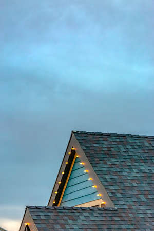 House with Christmas lights on the edge of roof with a close up of the roof and sky with lots of...