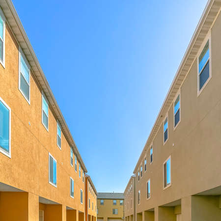 Back view of residential buildings against blue skyの写真素材