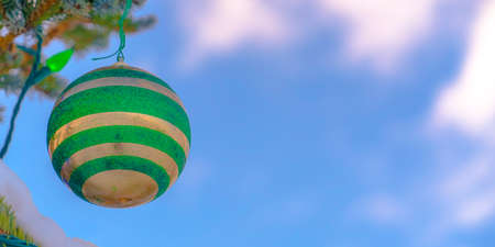 Bauble and lights on a Christmas tree against skyの写真素材