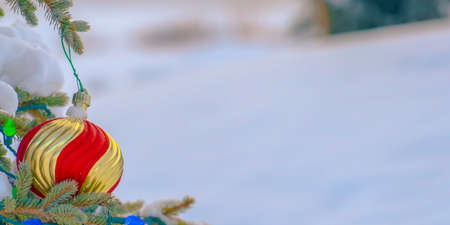 Bauble and lights on a tree against snowy groundの写真素材