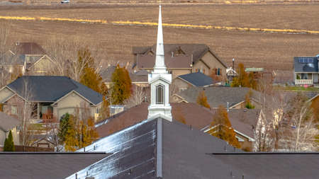 Church steeple towering over homes in Utah Valleyの写真素材