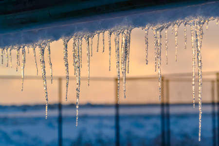 Close up of icicles formed at the edge of a roofの写真素材