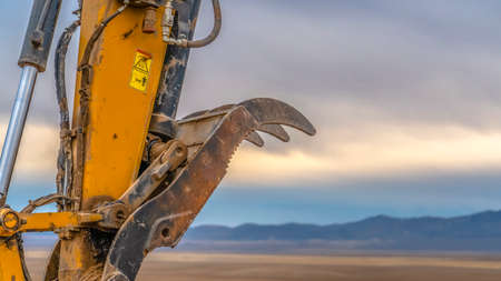 Excavator arm against mountain and sky in Utahの写真素材
