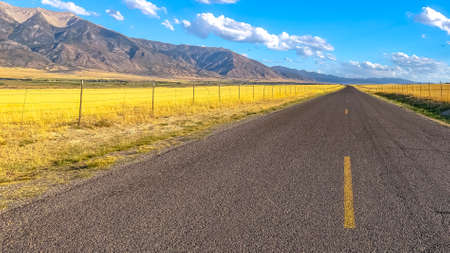 Highway with view of rugged mountain and blue skyの写真素材
