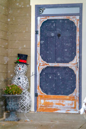 Home entrance with snowman and potted plantの写真素材
