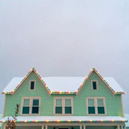 Home with snowy roof and Christmas lights in Utahの写真素材